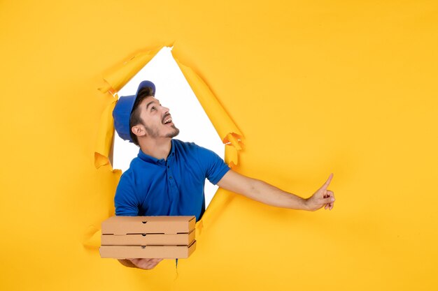 Front view male courier holding pizza boxes on yellow space