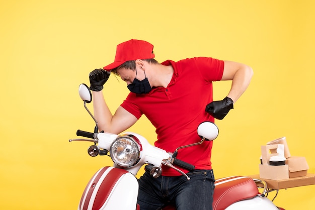 Front view male courier in uniform gloves and mask on yellow 