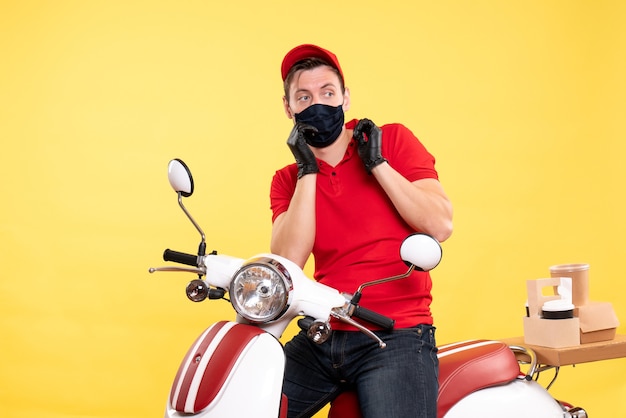 Front view male courier in uniform and mask on yellow 