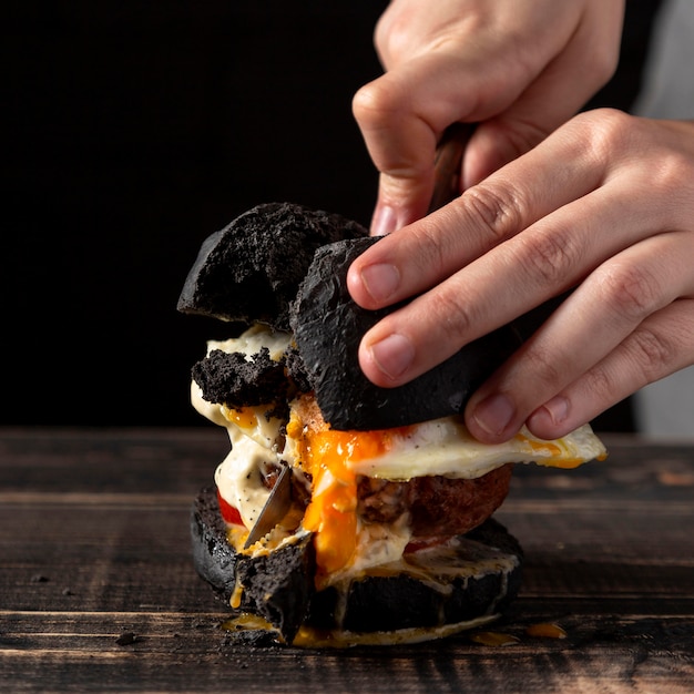 Free photo front view male cutting burger with egg