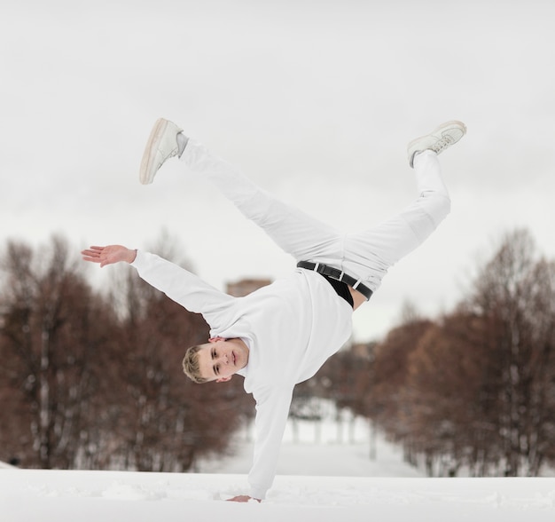 Front view of male dancer standing in one hand