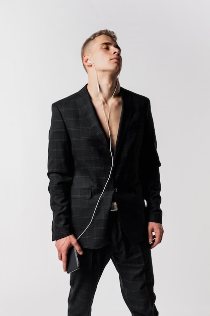 Front view of male dancer in suit enjoying music on headphones