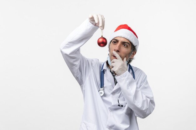 Front view male doctor holding toy on white wall virus covid health new year