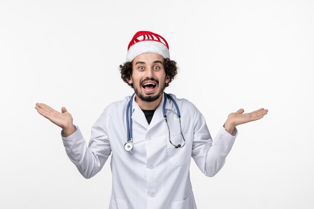 Front view of male doctor on light white wall