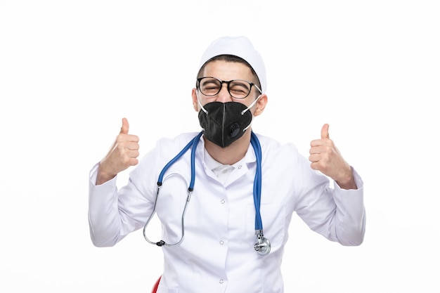 Front view male doctor in medical suit wearing special black mask