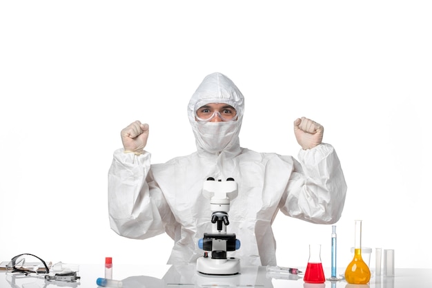 Free photo front view male doctor in protective suit and with mask smiling and rejoicing on the white space