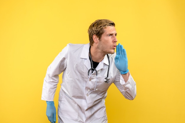 Free photo front view male doctor talking to someone on yellow background health medic human virus