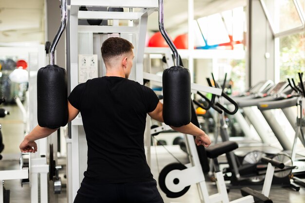 Front view male at gym doing arms exercise