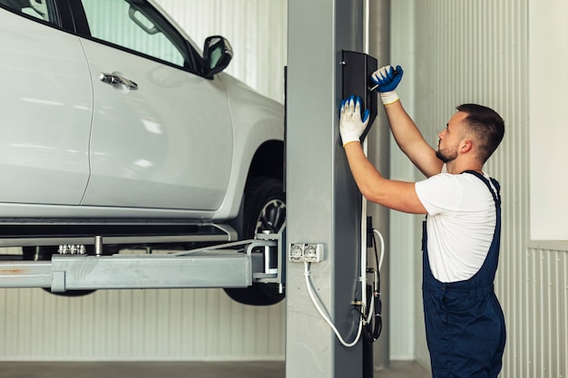 Front view male lifting up car for inspection