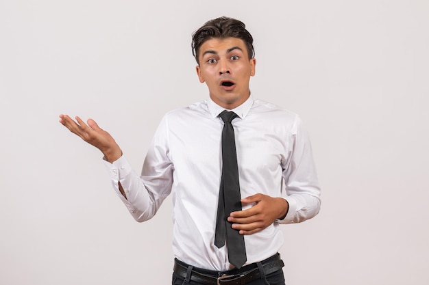 Front view male office worker standing on a white wall business work male job