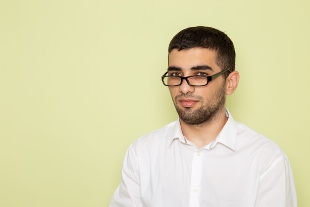 Front view of male office worker in white shirt just standing on the green wall