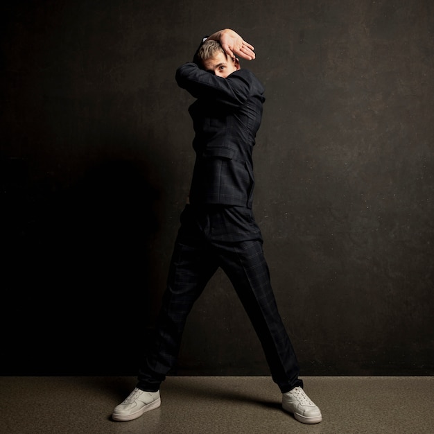 Front view of male performer in suit and sneakers dancing