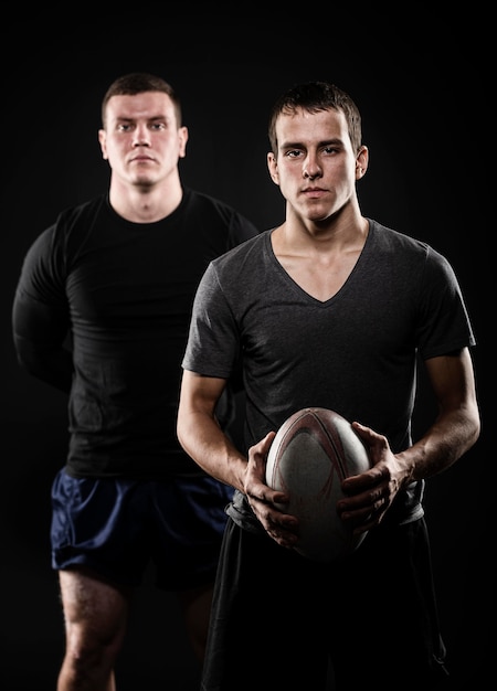 Free photo front view of male rugby players posing with ball