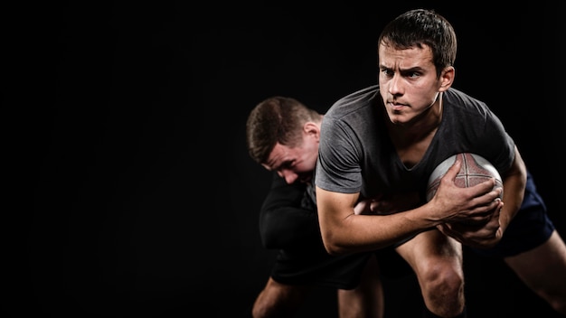 Front view of male rugby players with ball and copy space