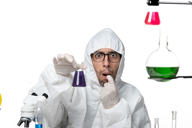 Free photo front view male scientist in special protective suit holding flask with solution