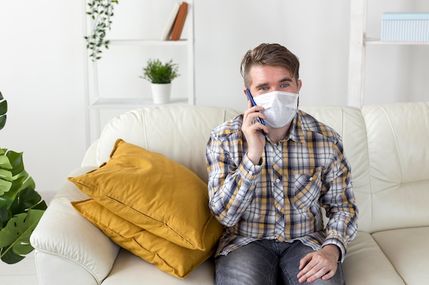 Free photo front view male with face mask talking on the phone