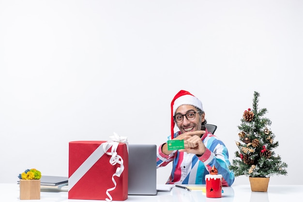 Front view male worker sitting in his working place holding green bank card office emotion christmas money job work