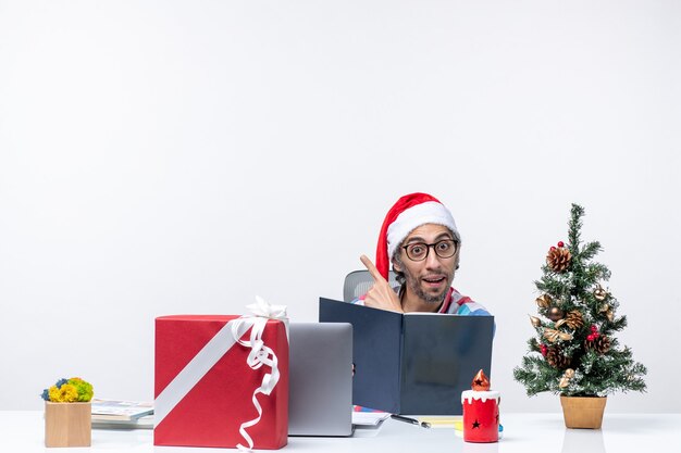 Front view male worker sitting in his working place reading copybook business job emotions christmas office