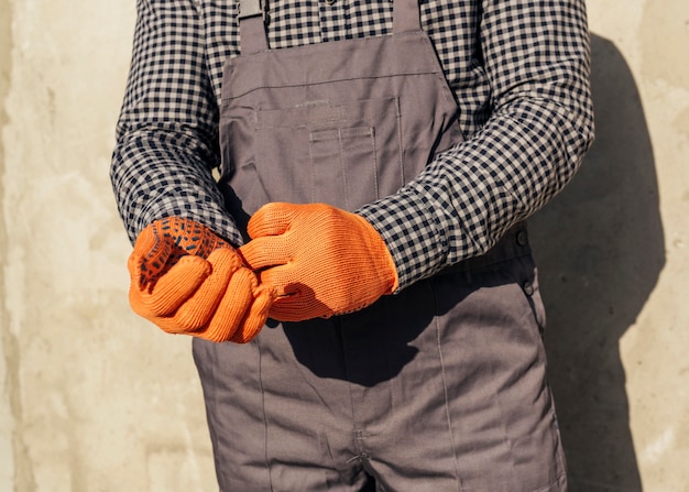 Free photo front view of male worker in uniform with protective gloves