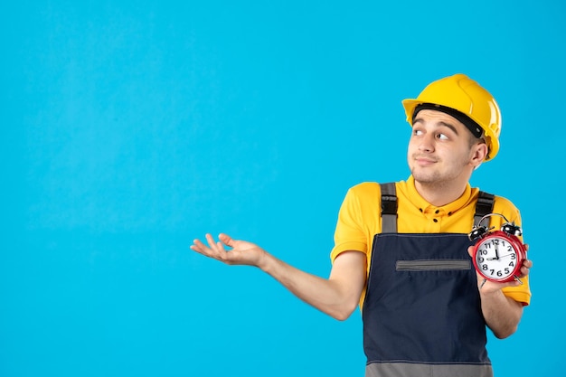 Front view of male worker in yellow uniform with clocks on blue 