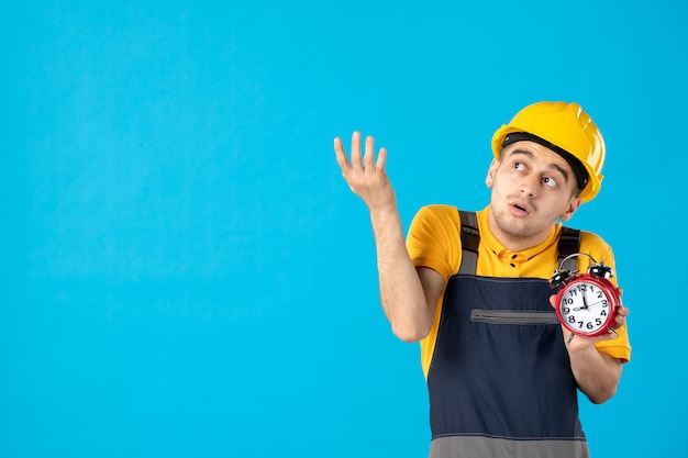 Front view of male worker in yellow uniform with clocks on blue 