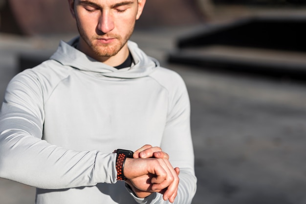 Free Photo front view man adjusting his sport watch