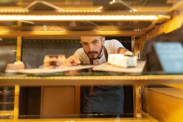 Front view of man arranging cookies in display