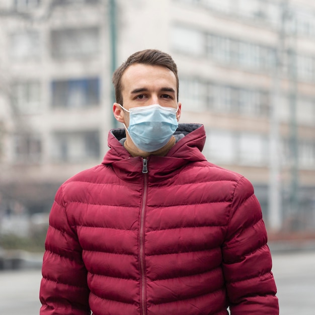 Front view of man in the city wearing medical mask