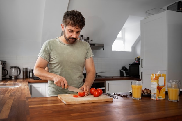 Front view man cutting tomatoes