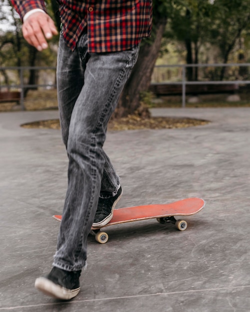 Front view of man doing tricks with skateboard outside in the park