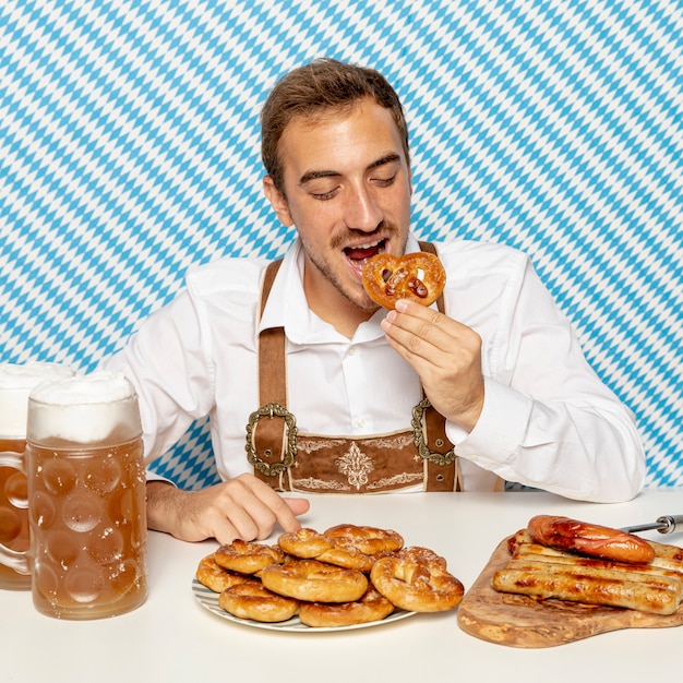 Free photo front view of man eating german pretzels