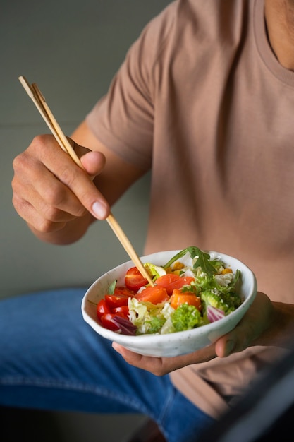 Front view man eating salmon bowl