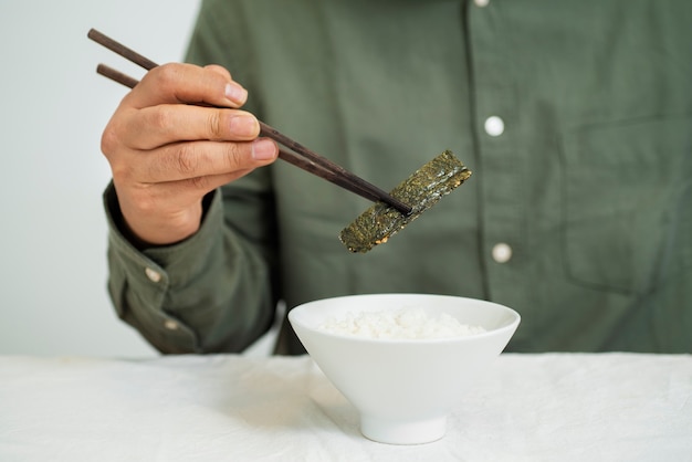 Front view man eating with chopsticks