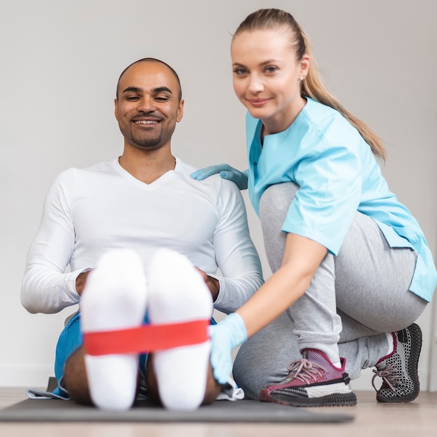 Front view of man and female physiotherapist doing exercises