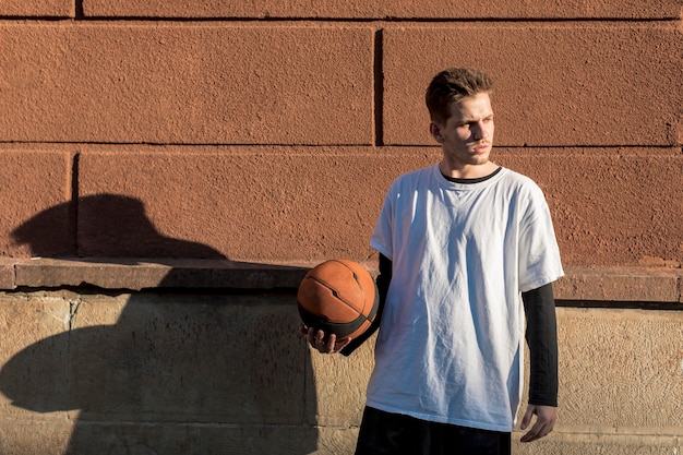 Free photo front view man holding a basketball