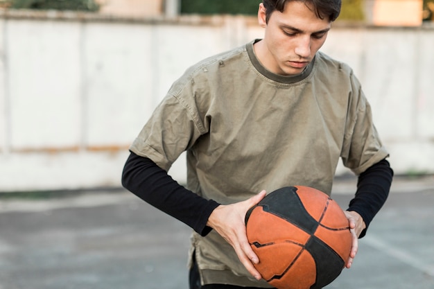 Free photo front view man holding a basketball