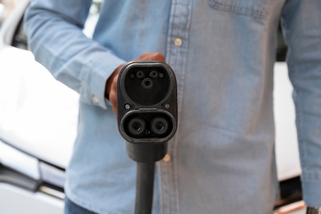 Front view man holding car charger