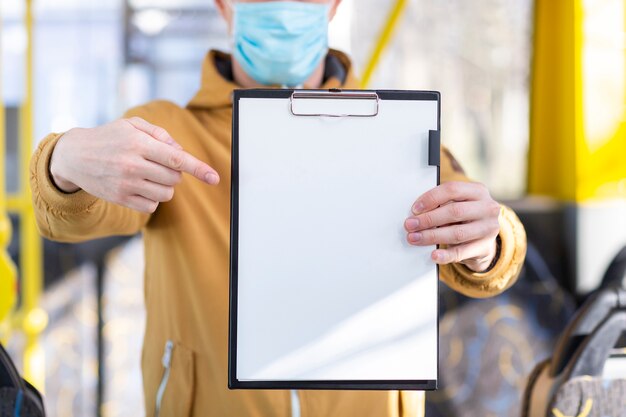 Front view man holding clipboard in public transport