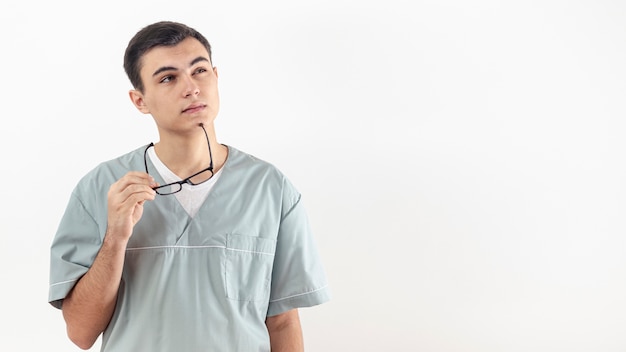 Front view of man holding his glasses to chin as if he's thinking