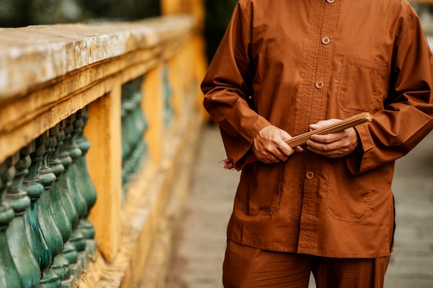 Free photo front view of man holding incense at the temple