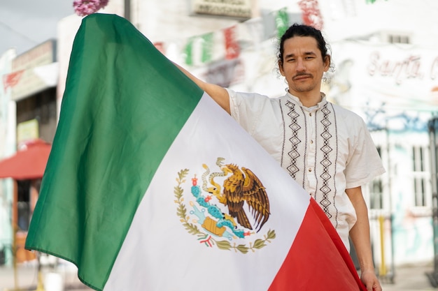 Front view man holding mexican flag