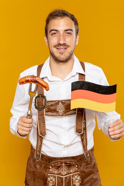 Front view of man holding sausage and flag