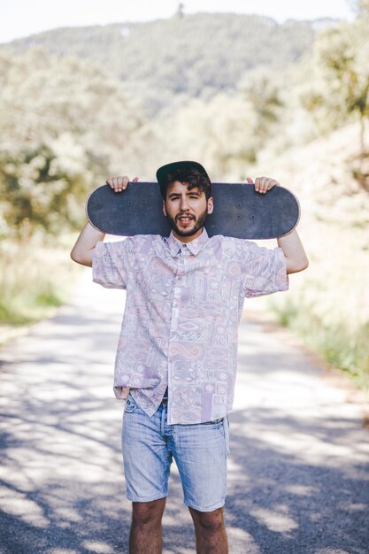 Front view of man holding skateboard