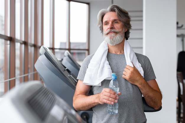 Front view man holding water bottle