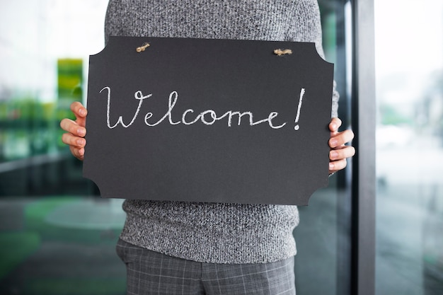 Free Photo front view man holding welcome signs