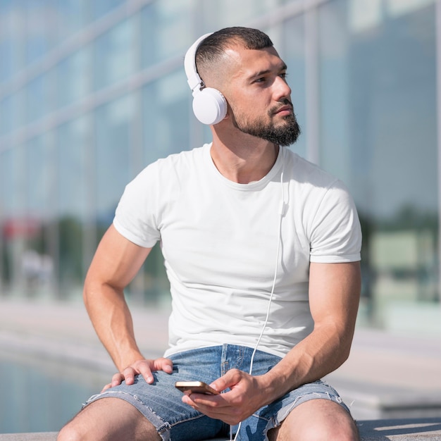 Free Photo front view man looking away while listening music