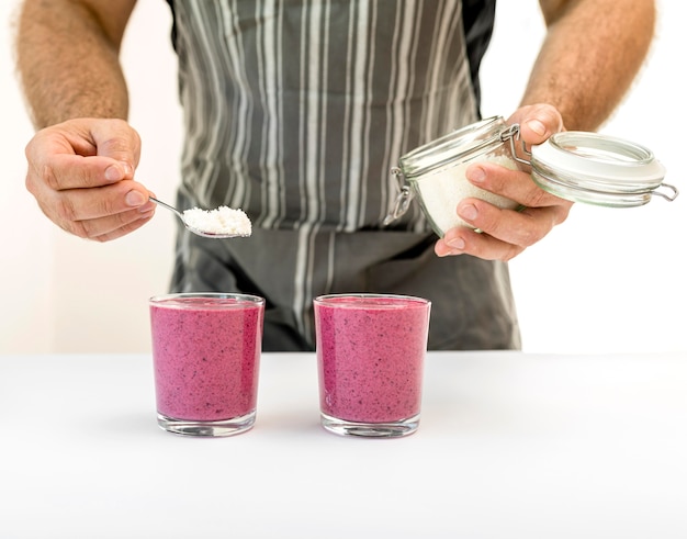 Free photo front view man making a smoothie