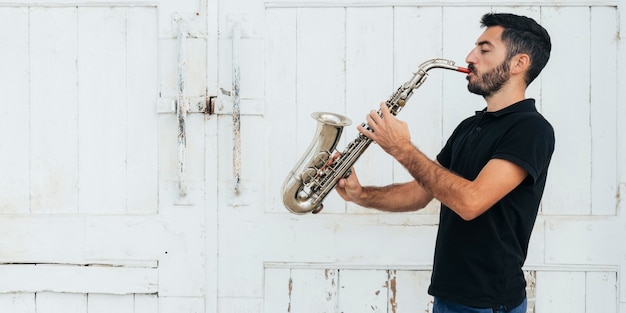 Free photo front view of man playing the saxophone