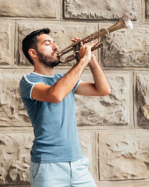 Free photo front view of man playing the trumpet