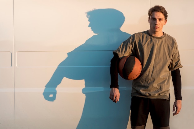 Front view man posing with a basketball